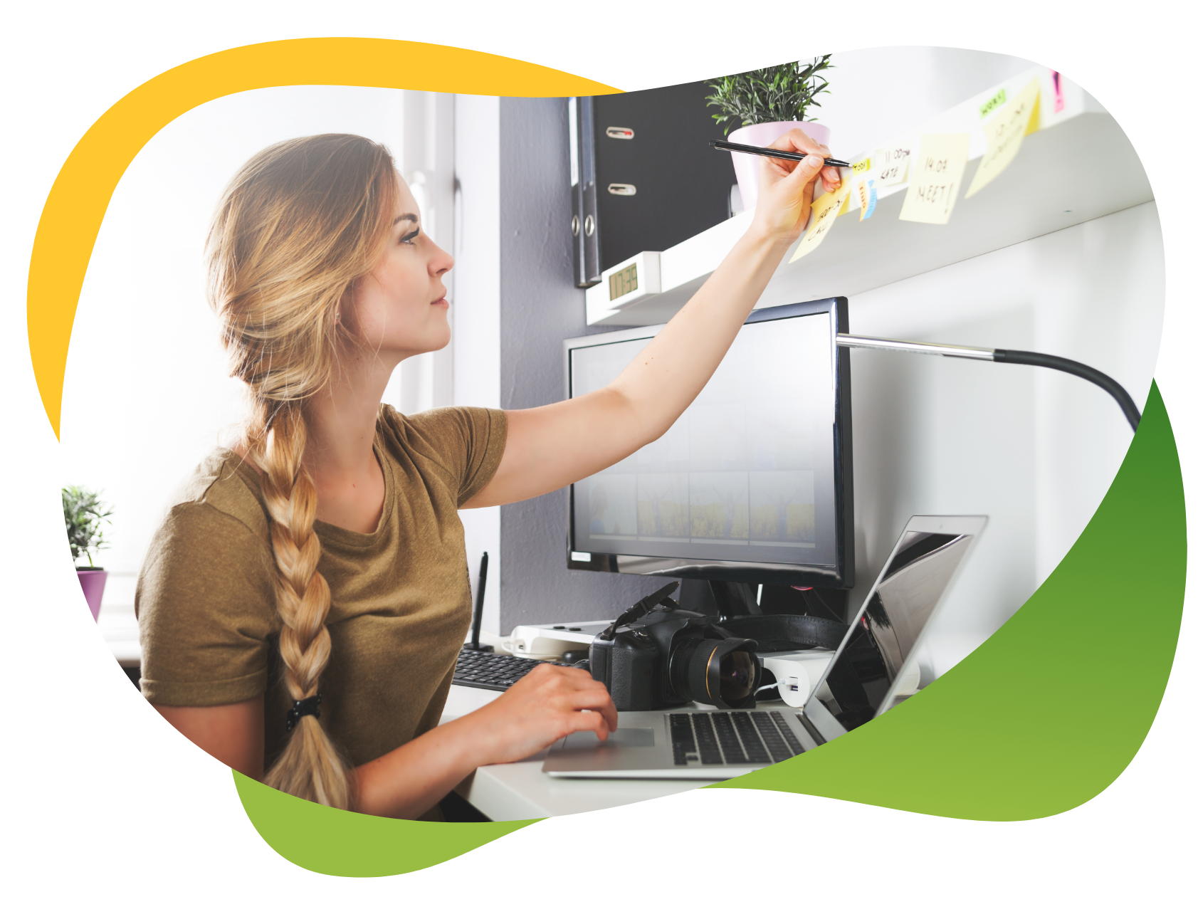 A young woman with blonde braided pigtail sits at her desk making notes on her post it