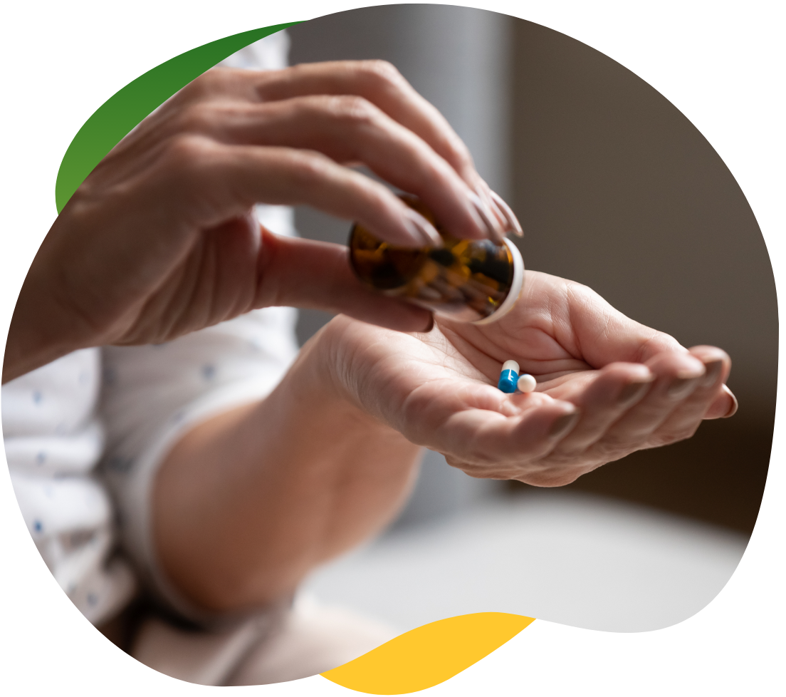 Woman’s hand pouring the medicine out of the bottle on her left palm