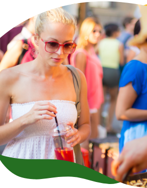 A blonde woman in summer white top and sunglasses at a food stall